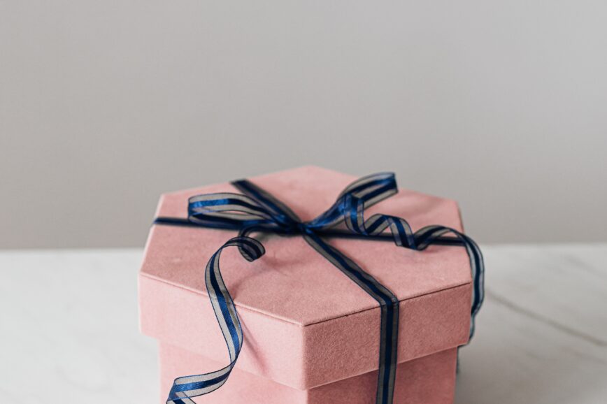 light pink gift box with navy blue ribbon